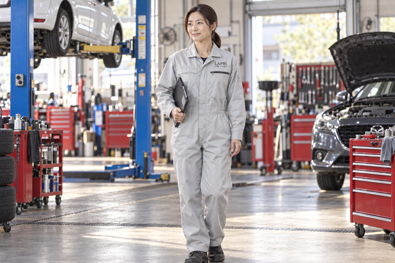 自動車整備工場でSOWAのつなぎを着用し、左胸にLAPRI Life+Printをプリントしたイメージ